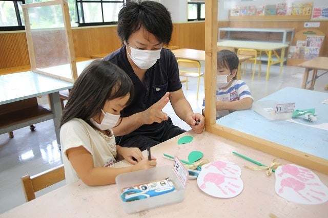 お父さんに教えてもらいながらおじいちゃんおばあちゃんへのメッセージを書きます。