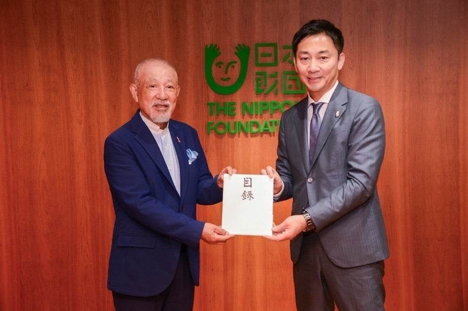 島田慎二チェアマン(右)から日本財団会長の笹川陽平へ目録が手渡される