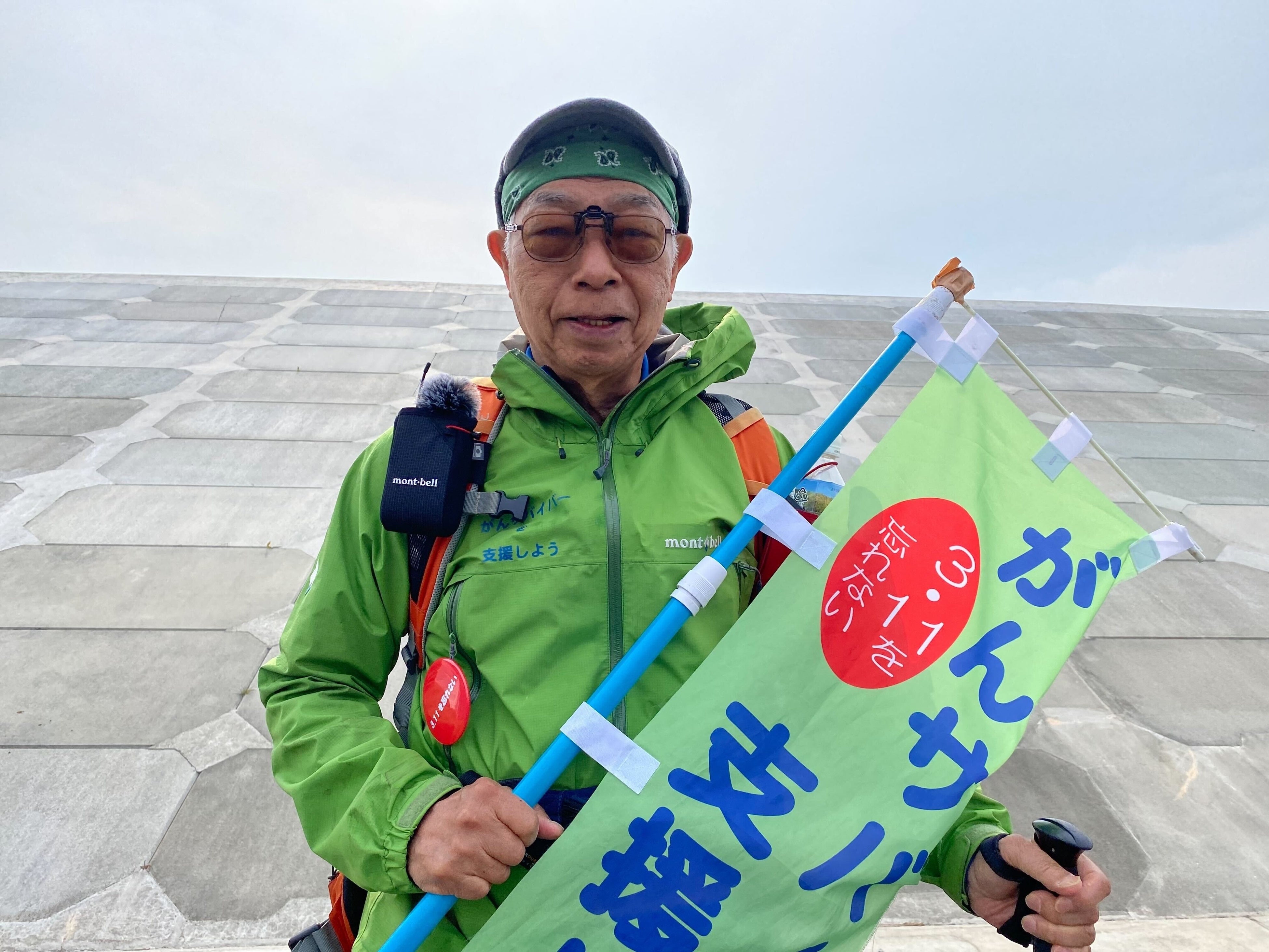 高さ9.7ｍの防潮堤を背にする垣添会長＝４月５日、岩手県山田町