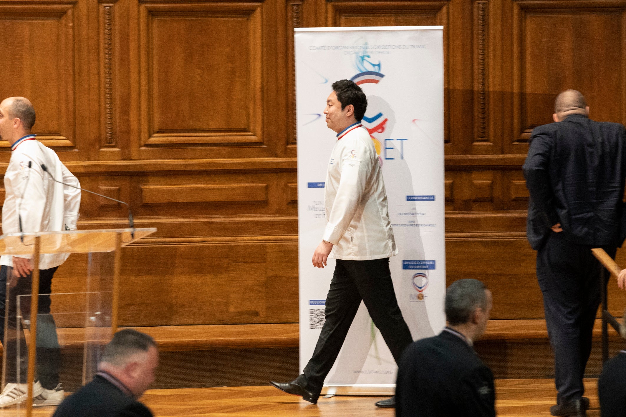 料理部門の受章を迎え、檀上に向かう