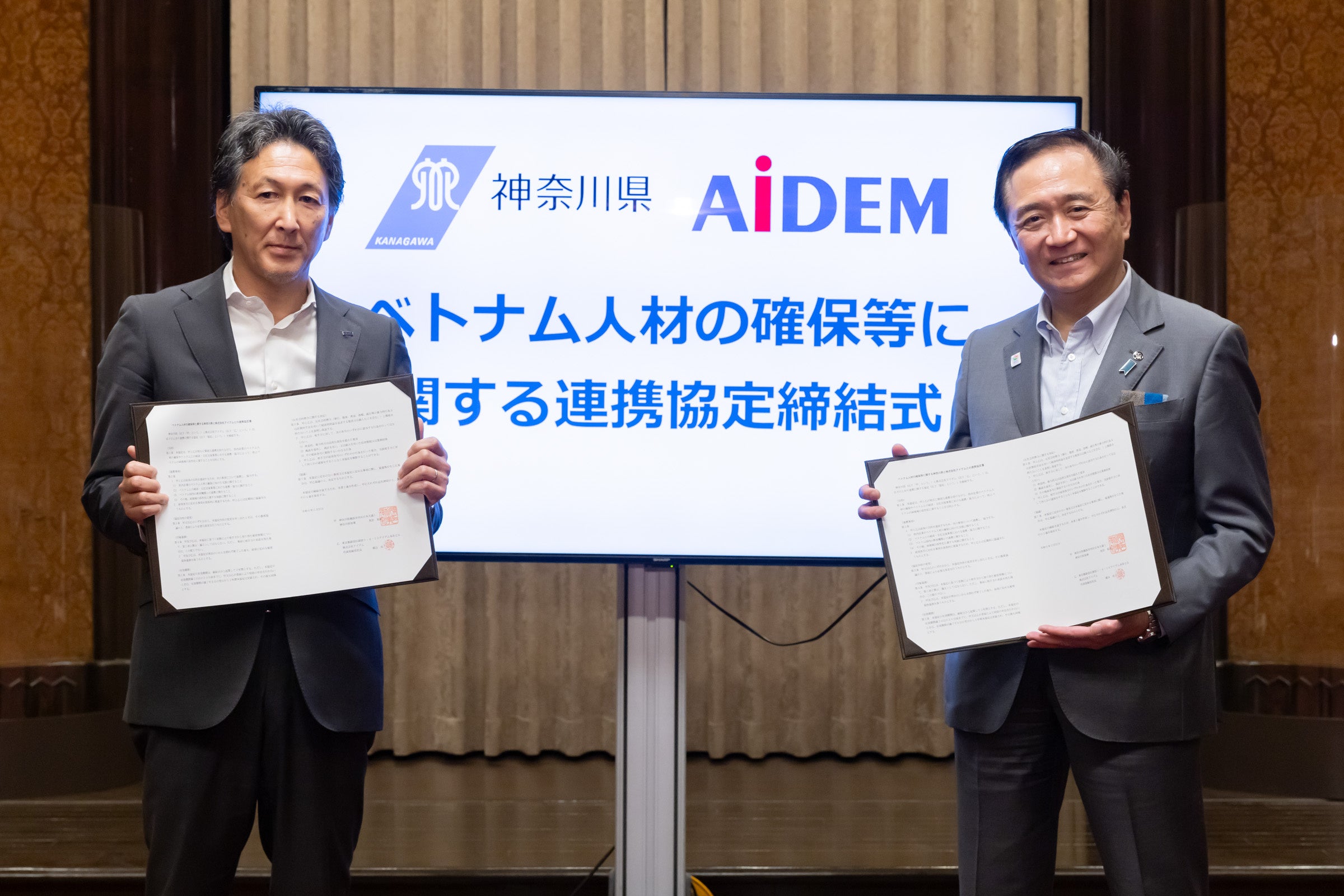 【左から　株式会社アイデム 取締役本部長 臼井 浩一、神奈川県知事 黒岩 祐治 様】