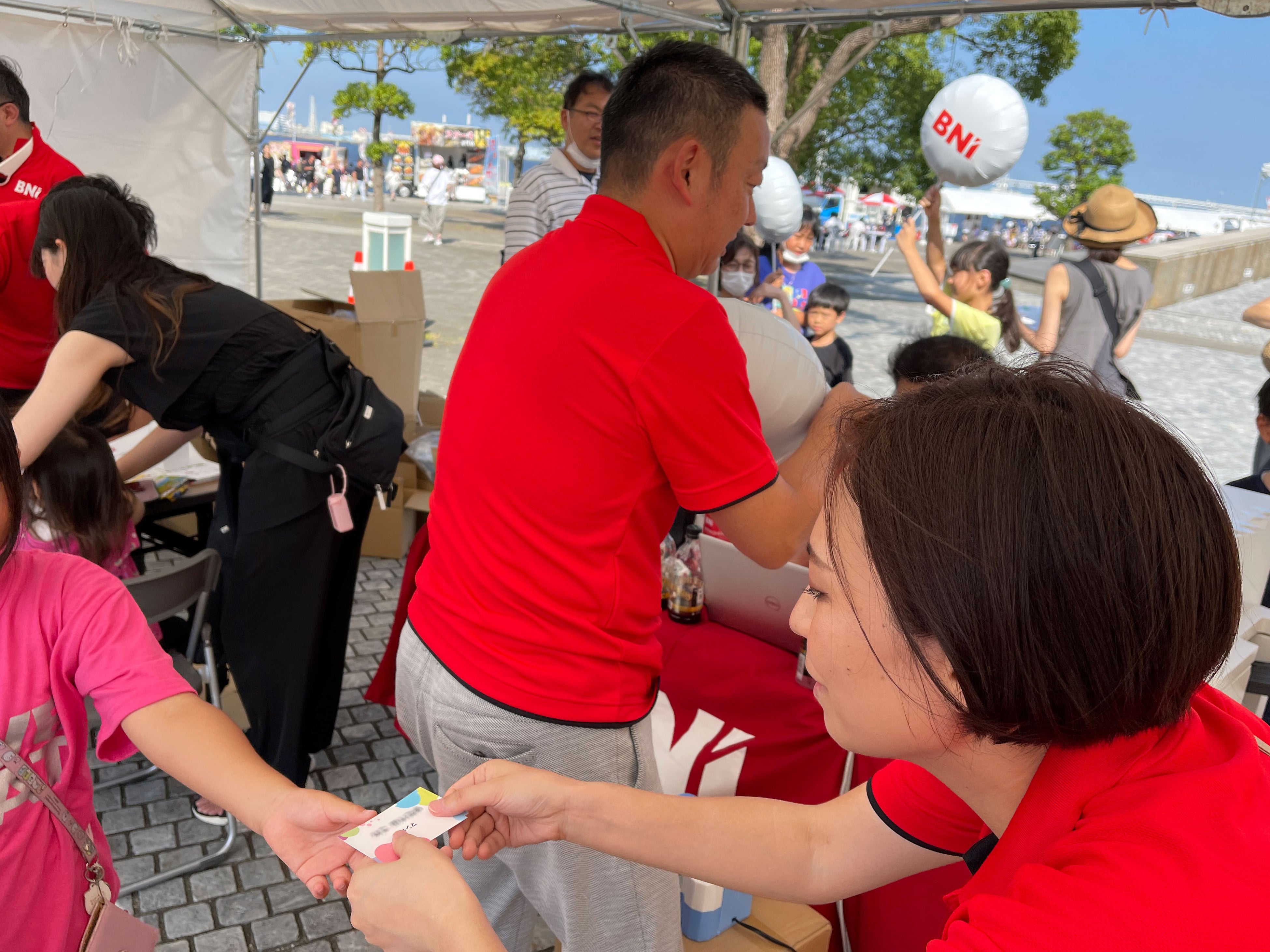 出来上がった名刺を渡すBNIスタッフ