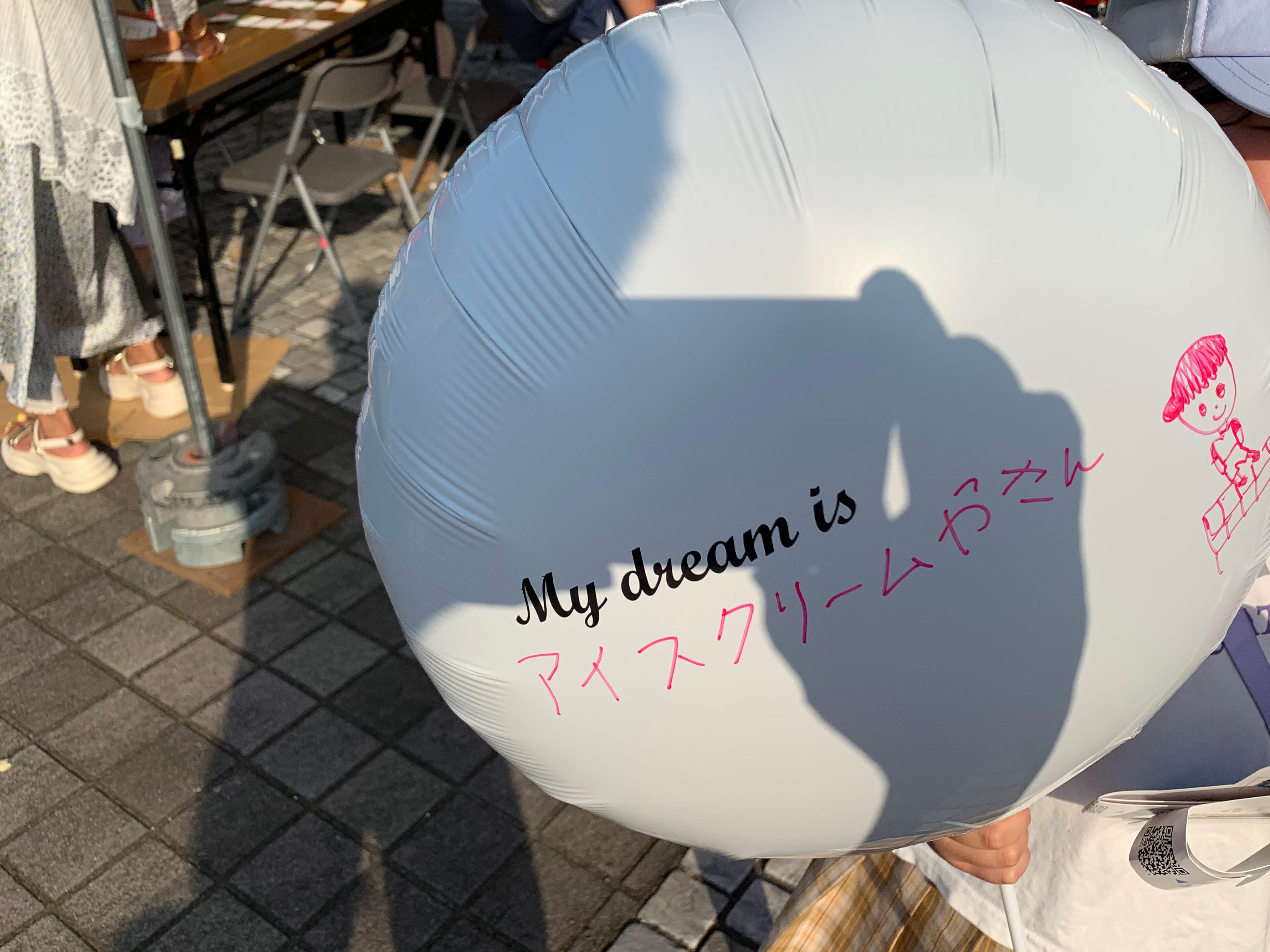 自分の夢を描いたバルーンを持つ子ども