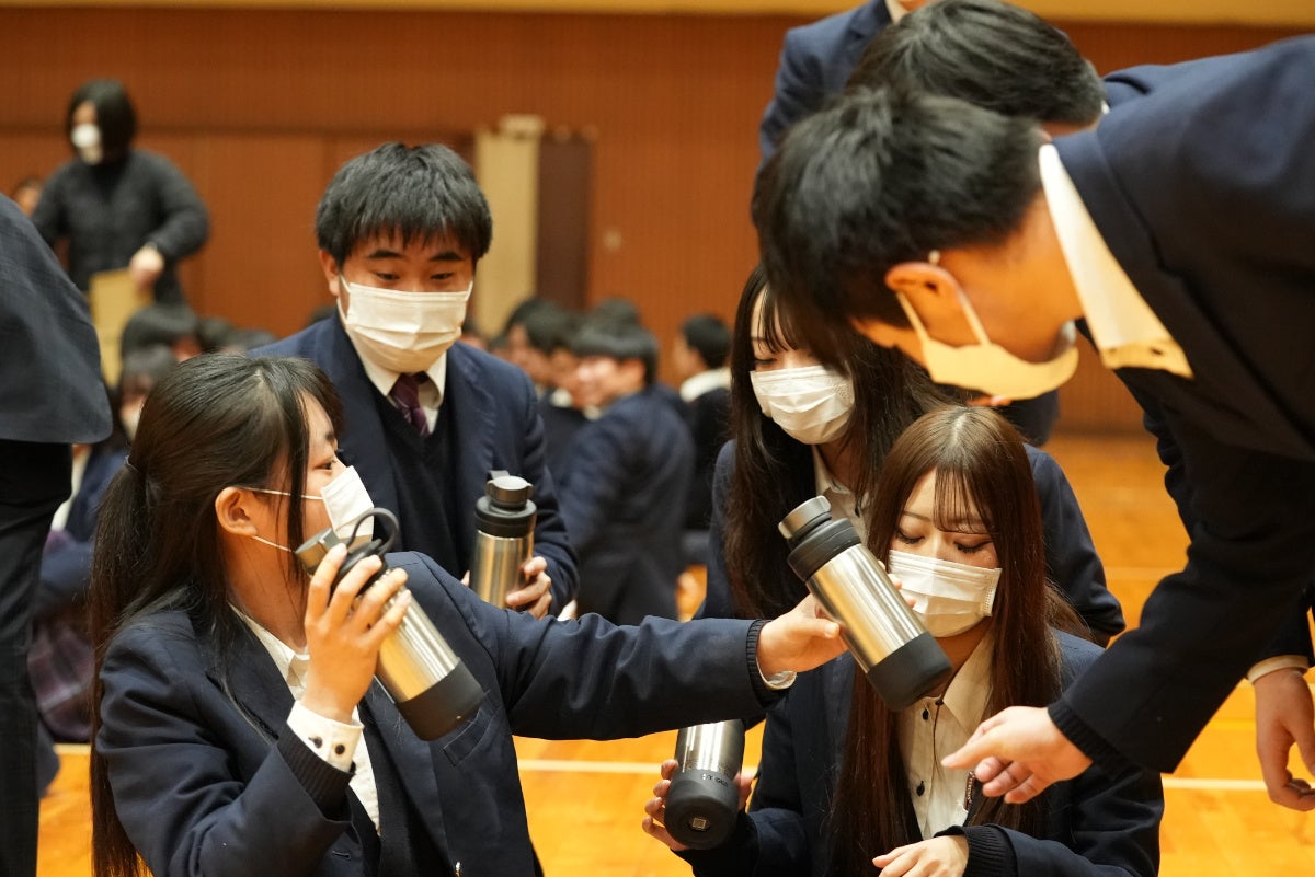 ボトルを手に驚いている卒業生の様子