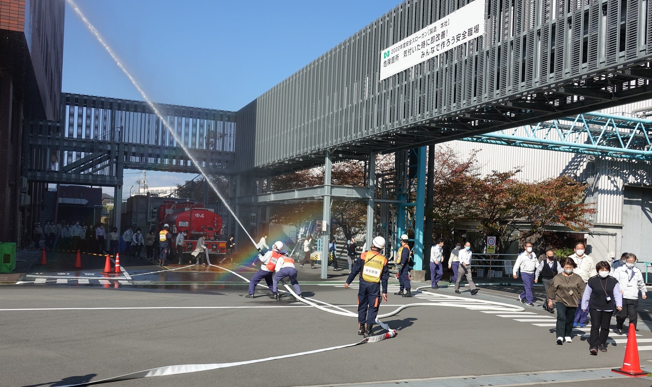 ▲初期消火班による放水の様子と、ビルから避難する従業員