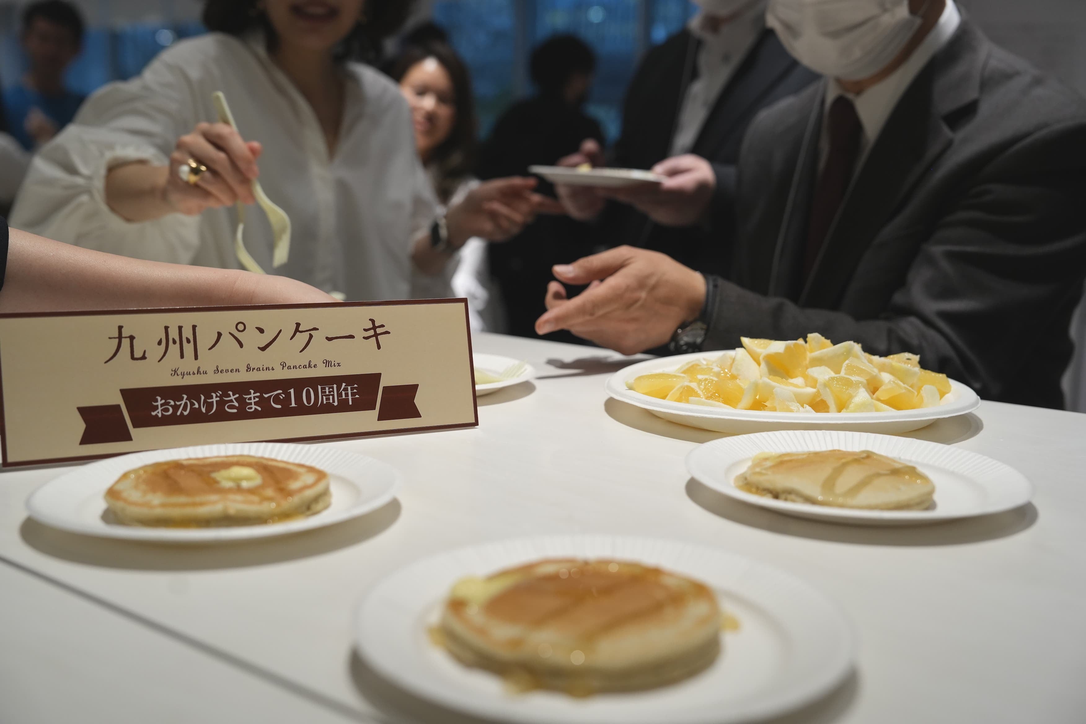 焼きたてのパンケーキを手に交流する参加者の様子