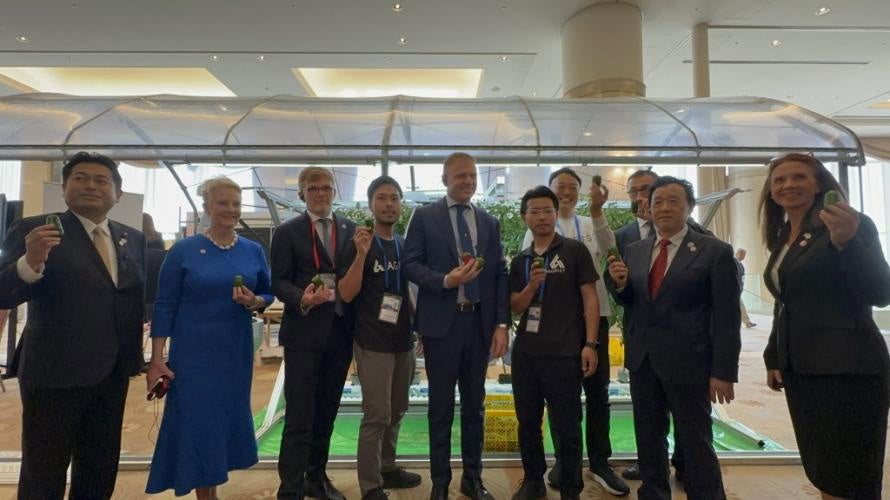 G7宮崎農業大臣会合の各国要人と収穫ロボット展示前で記念撮影するAGRISTメンバー