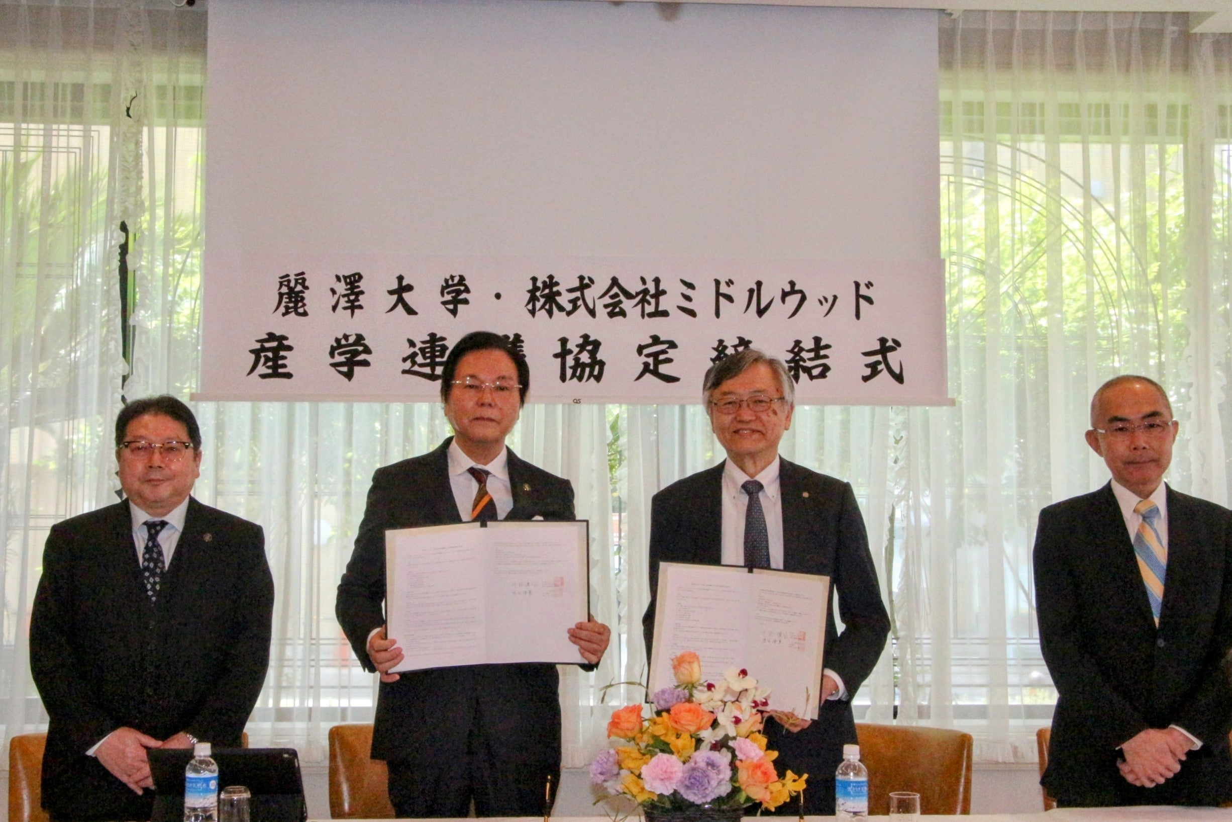 協定書にサインを終えたミドルウッド代表取締役：中野讓冶（左2）・麗澤大学学長：徳永 澄憲（右2）