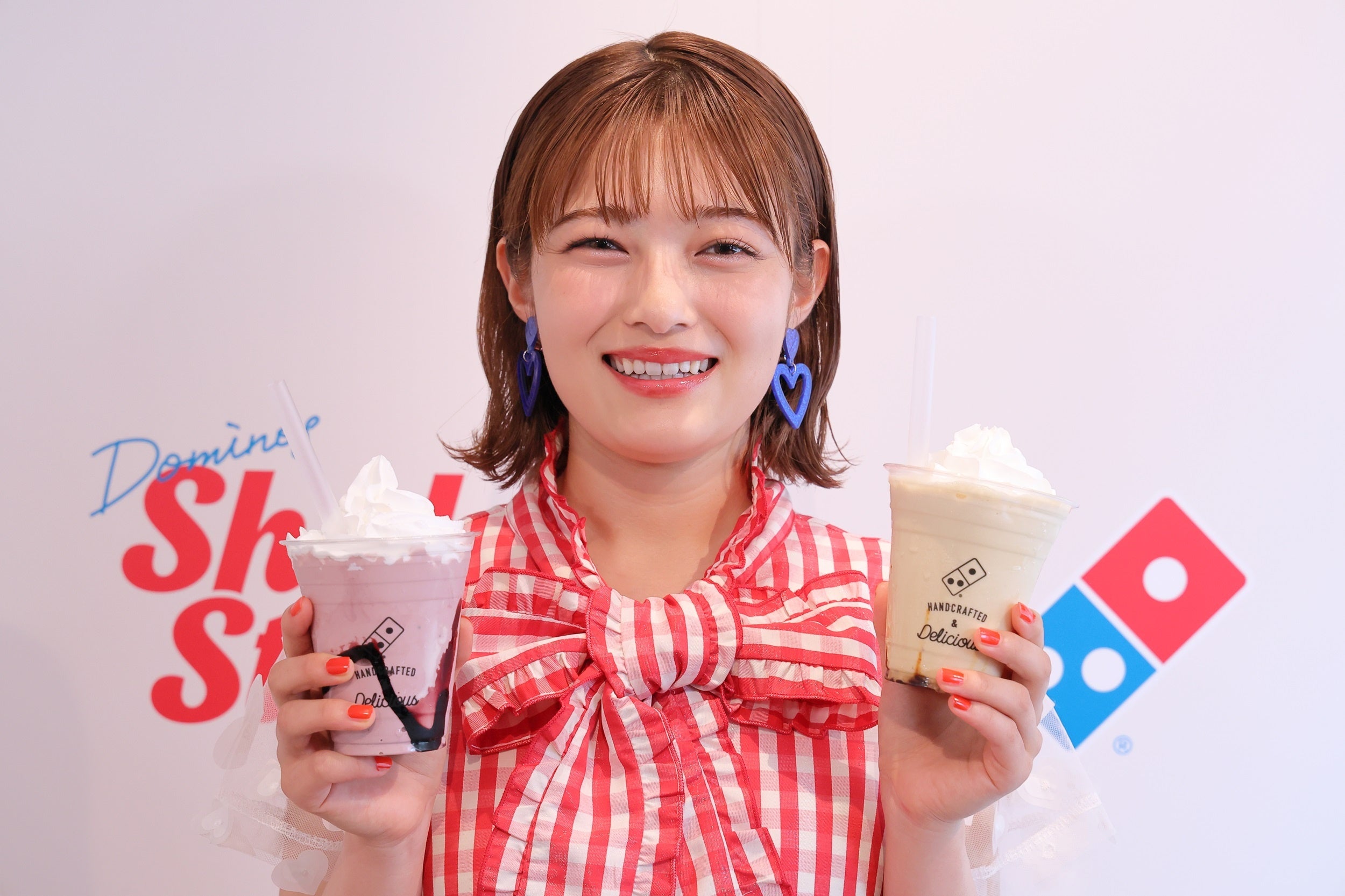 「ドミノシェイク  カシス」を右手に持ち、 絶賛する井上咲楽さん