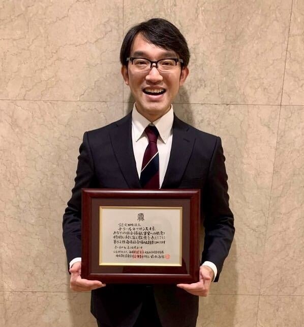 賞状を手にする創設者・鬼丸