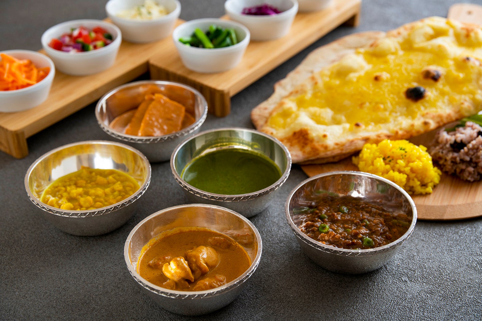 5種類のカレーに加えて、インド風のスパイシーサラダや小松菜・人参・紫キャベツのアチャール（インド風ピクルス）なども。