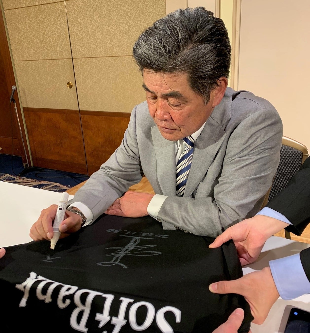 プレゼントグッズにサインをする工藤公康さん