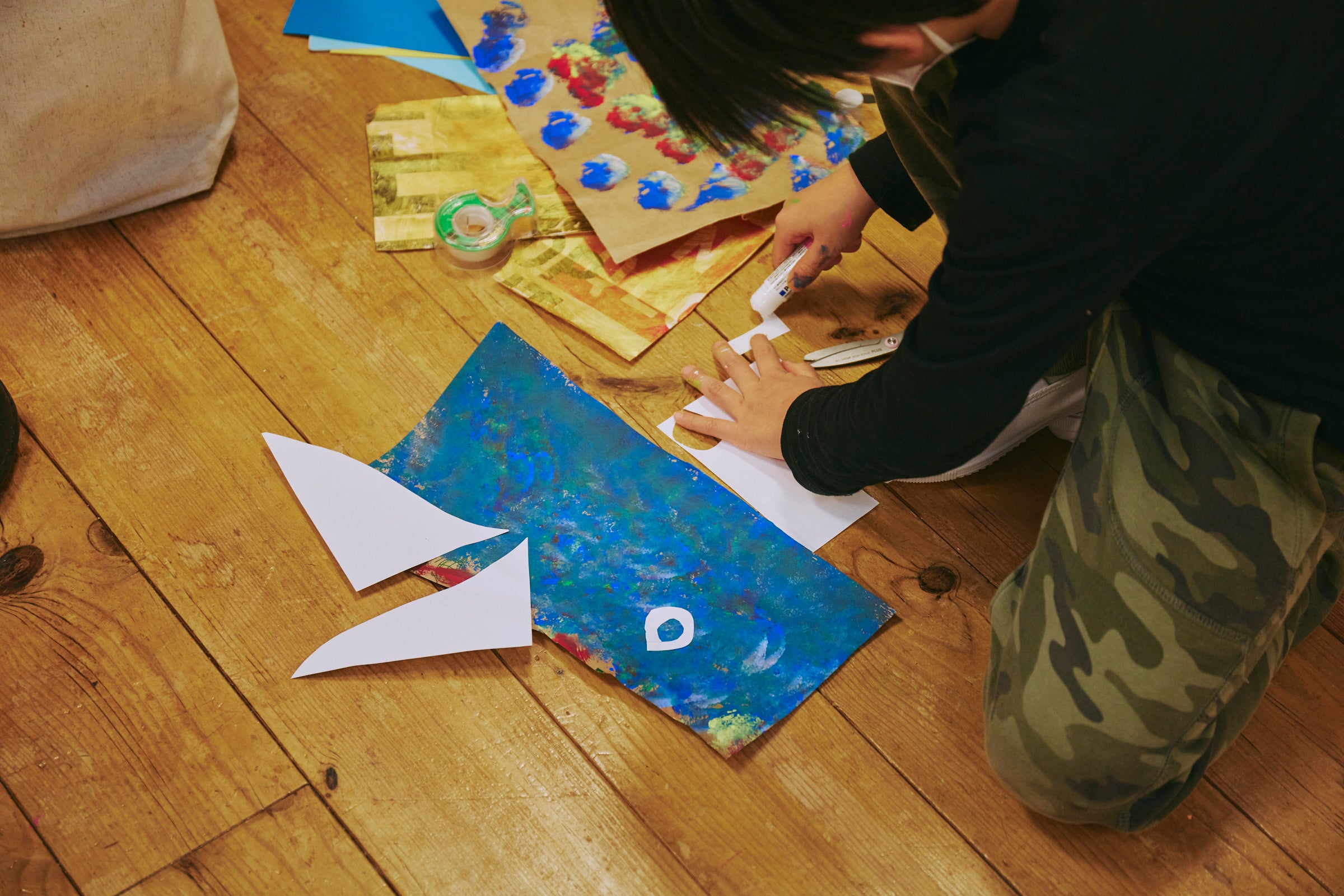 （色をつけたショッピングバックを切り、鳥のモチーフにする様子）