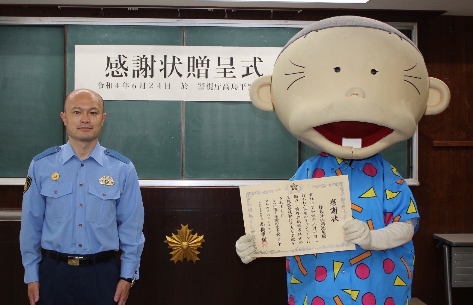 感謝状贈呈式の様子（警視庁高島平警察署 髙橋季樹署長とヒーおばあちゃん）