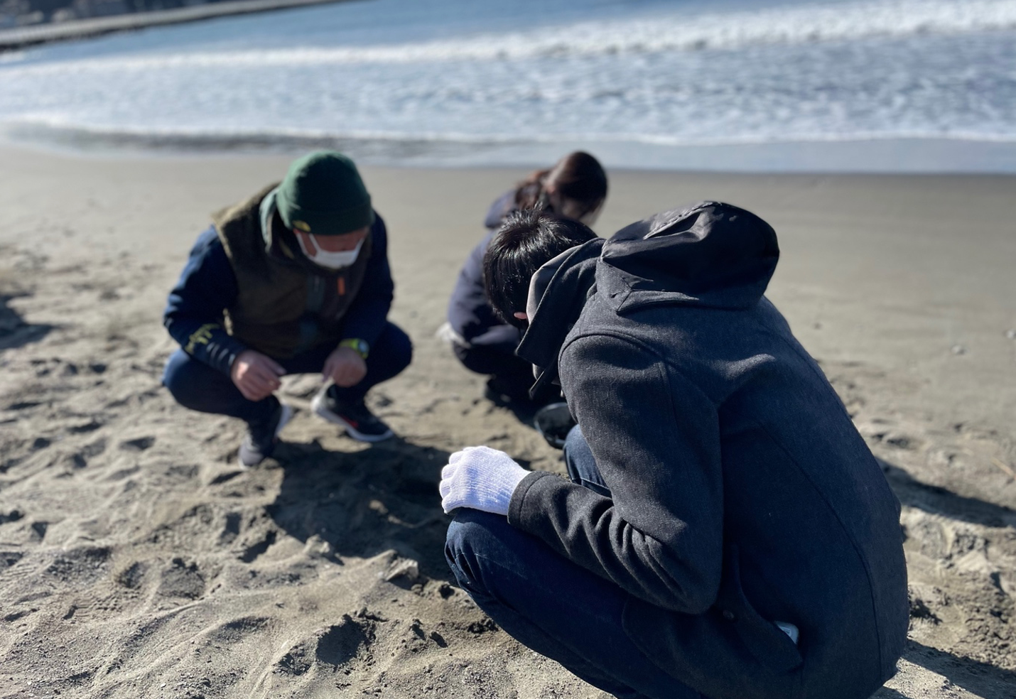 【写真】チームで集まりビーチクリーン活動