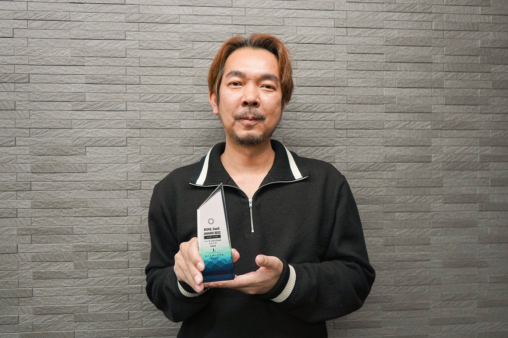 トロフィーを持つスパイダープラス代表取締役CEO 伊藤謙自
