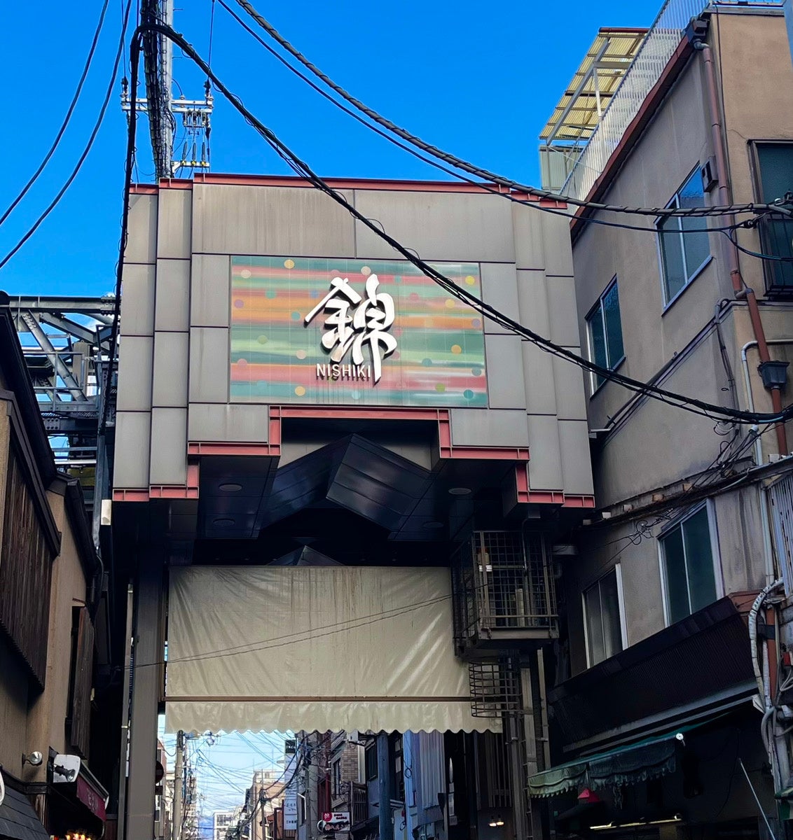 京の台所、400年の歴史 錦市場は京都市内の目抜き通り「四条通り」の1本北に位置し、錦小路通の寺町から高倉まで東西390メートルにもなる「京の台所」と言われる「商店街」です。400年の歴史を持ち、京都市民からは「にしき」という愛称で呼び親しまれています。