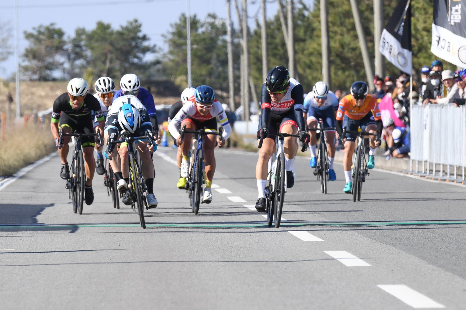 M　フィニッシュライン上でのハンドルの投げ合いは僅差で小玉篤志（Team FunCycle ※オープン、左から2人目）