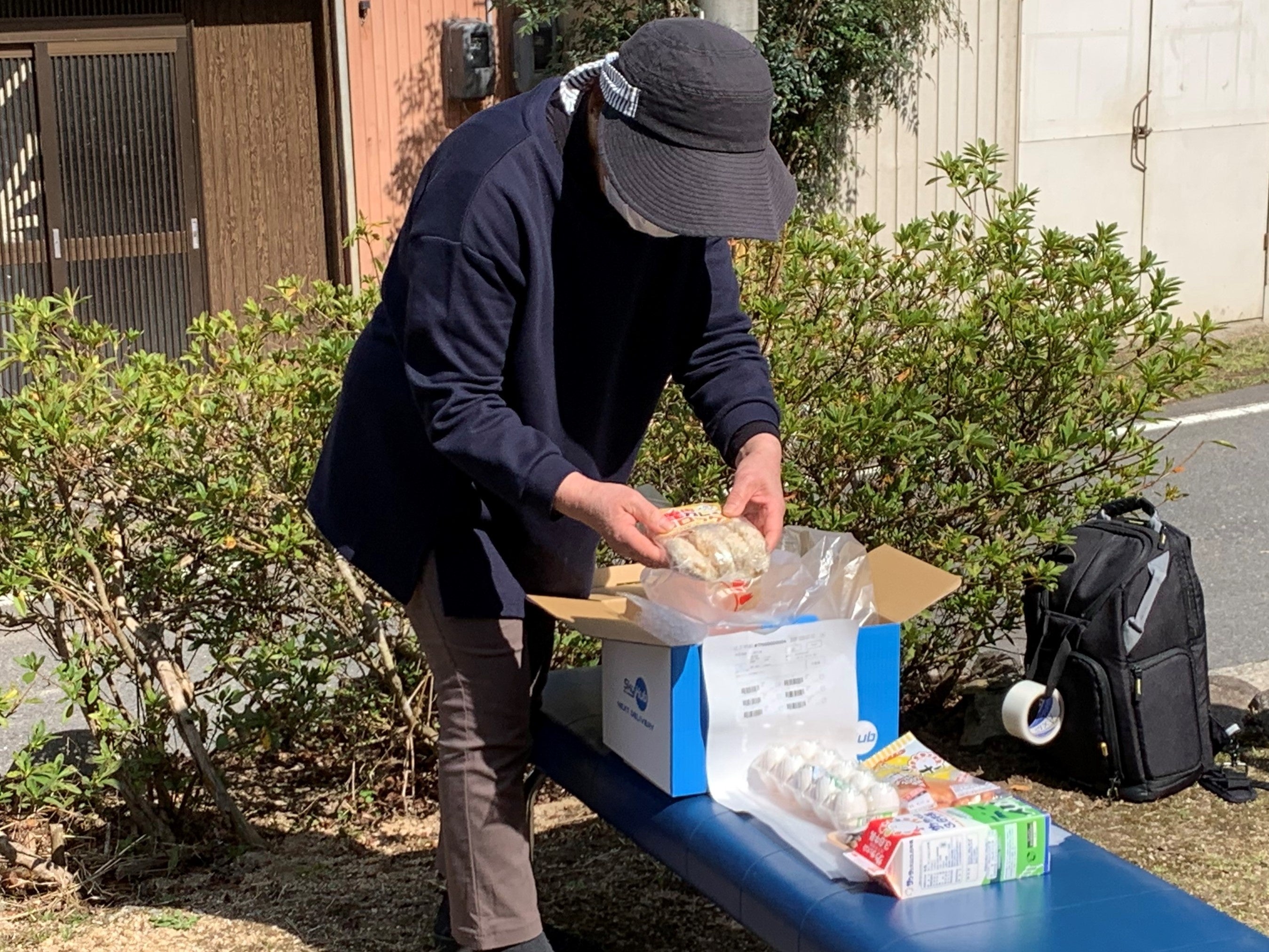 今回ドローン配送で受け取った玉子、牛乳、鹿コロッケ等注文の品を確認する中山勝恵さん（共生の里 しこべの家）