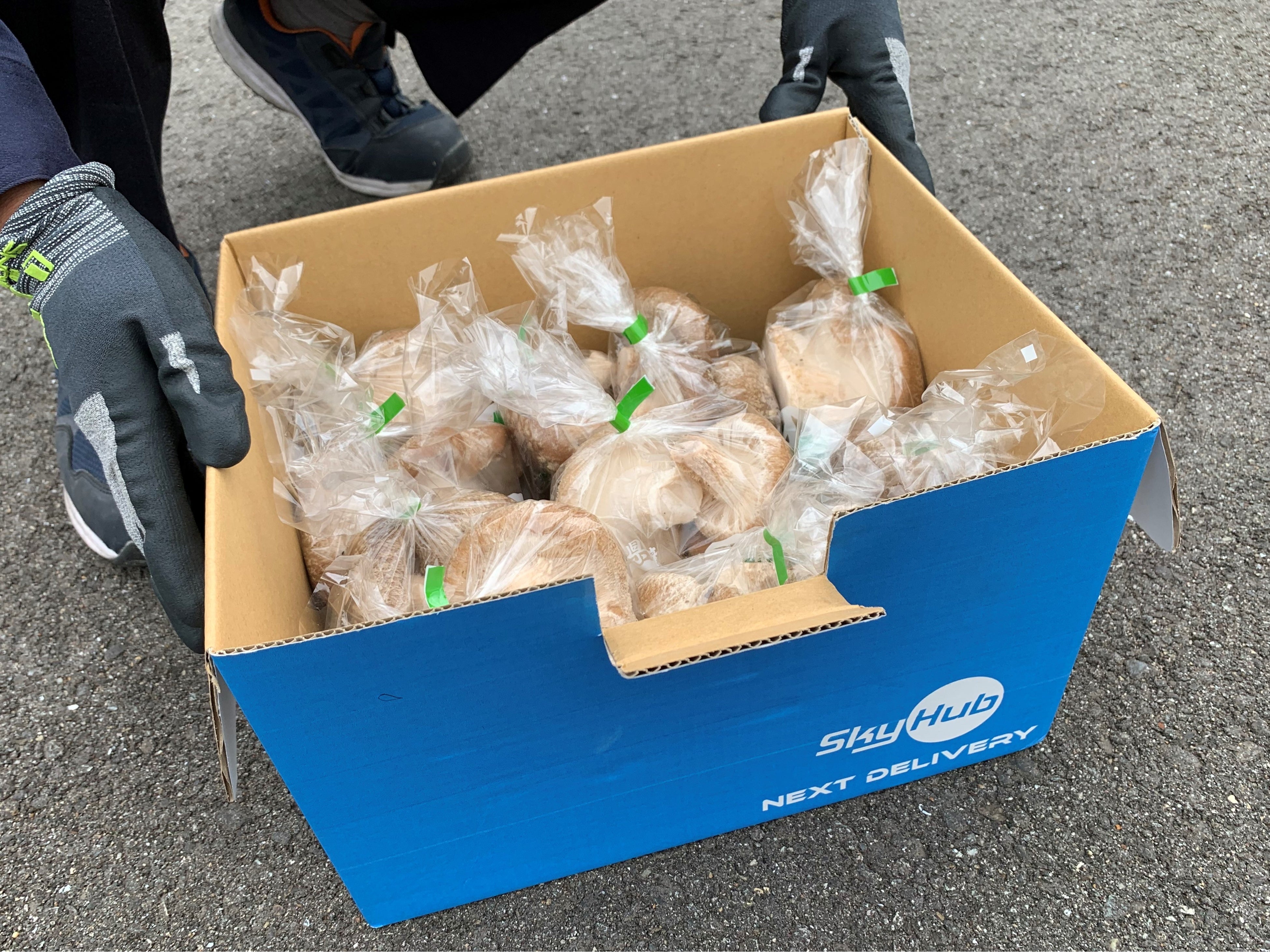 ドローンと車のリレー配送でJAまで届けられた佐那河内村産シイタケ （佐那河内村役場駐車場）