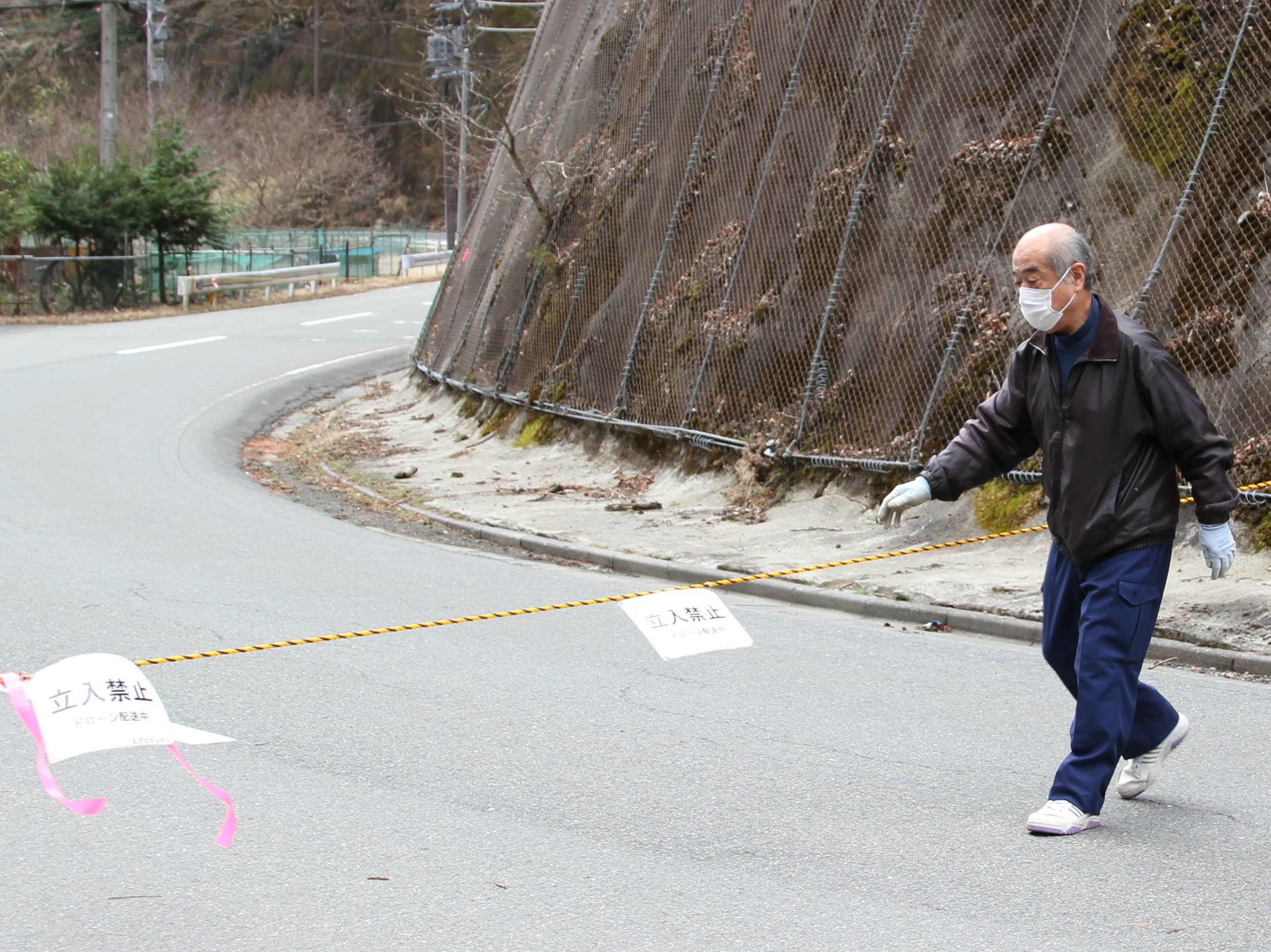 規制線のロープを張る中津川区長 （崩落地点を超えた先の着陸地点）