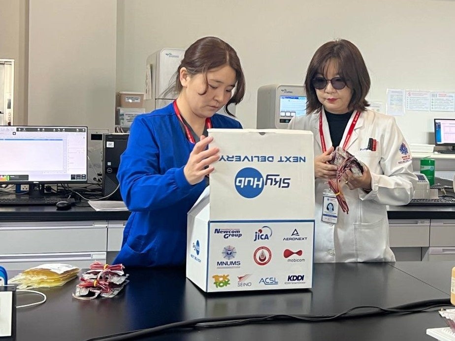 ドローン配送された箱を受け取り中の血液を確認するモンゴル国立医科大学付属モンゴル日本病院の看護師