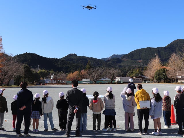 12月3日と4日、実証実験で日本発物流専用ドローン AirTruckの離陸を見守る本川根小学校の生徒たち