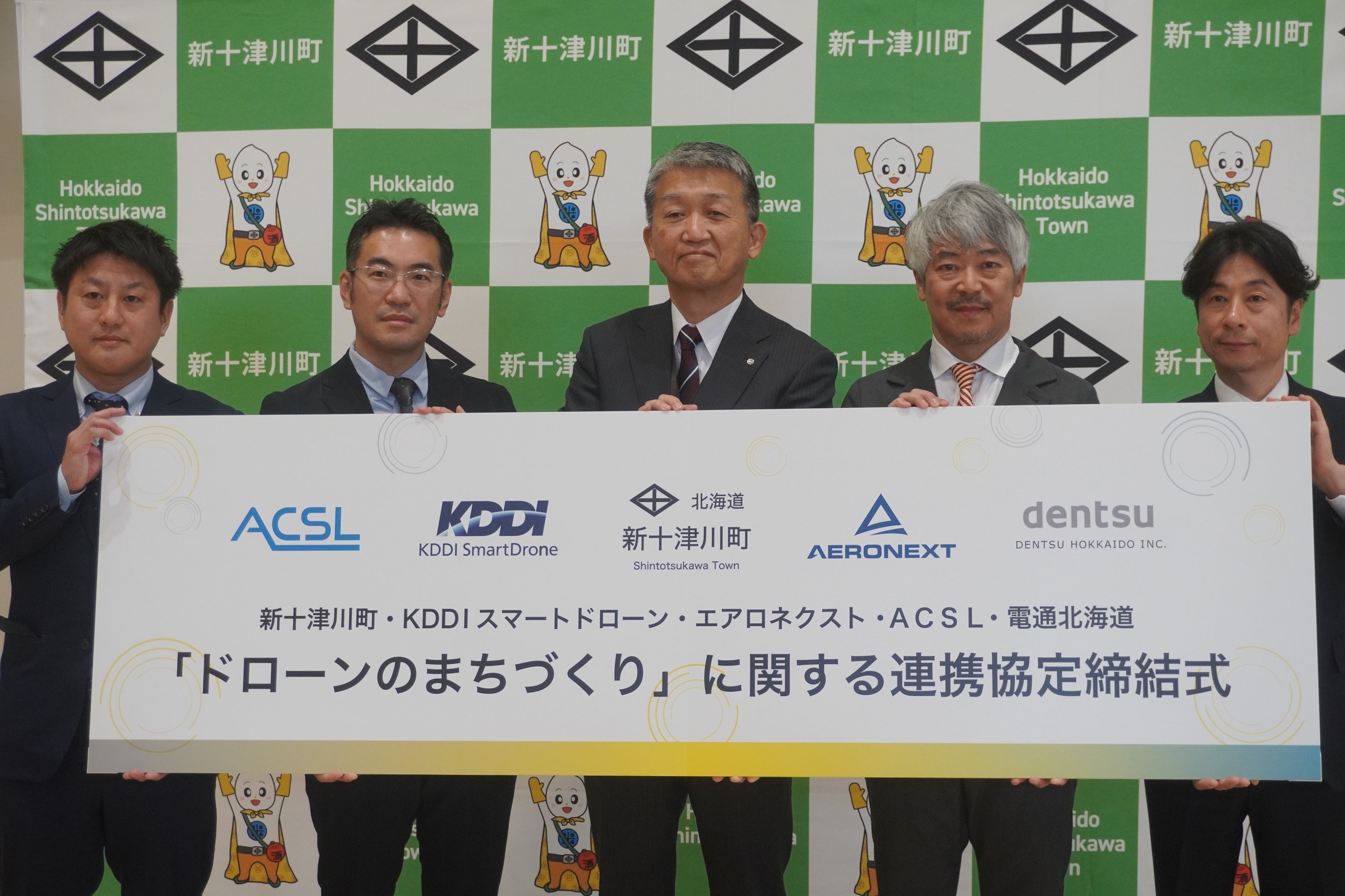 写真向かって左よりＡＣＳＬ CMO六門 直哉、KDDIスマートドローン 代表取締役社長 博野 雅文、新十津川町長 谷口 秀樹、エアロネクスト 代表取締役CEO 田路 圭輔、電通北海道 代表取締役社長執行役員 木村 平