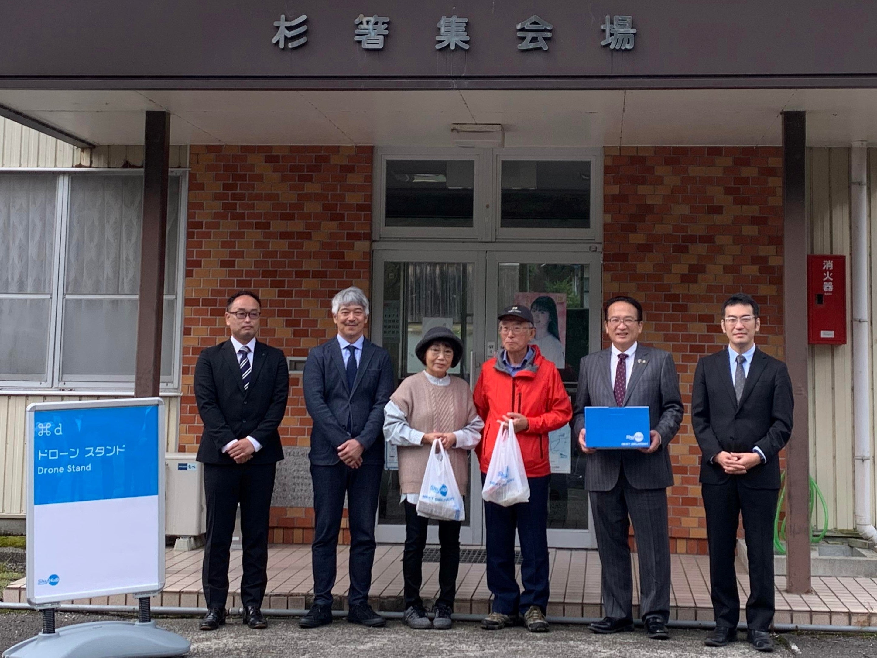 SkyHub®Storeサービスのドローン配送を終えて記念撮影（愛発地区杉箸集会所前）