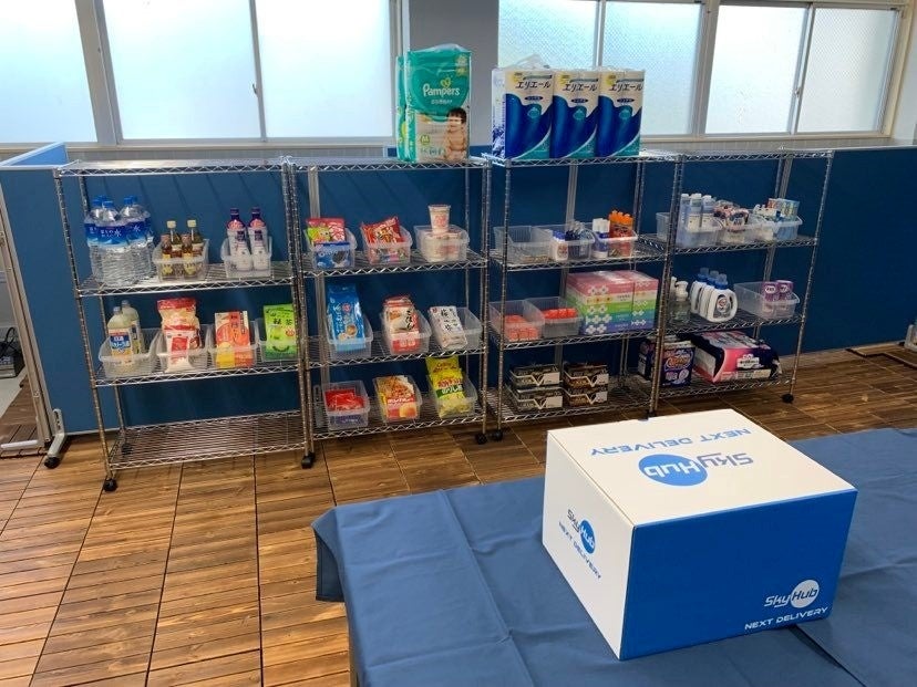 愛発公民館（旧愛発小中学校）の元給食室を改装した「ドローンデポ®愛発」の内部とドローン配送用の箱