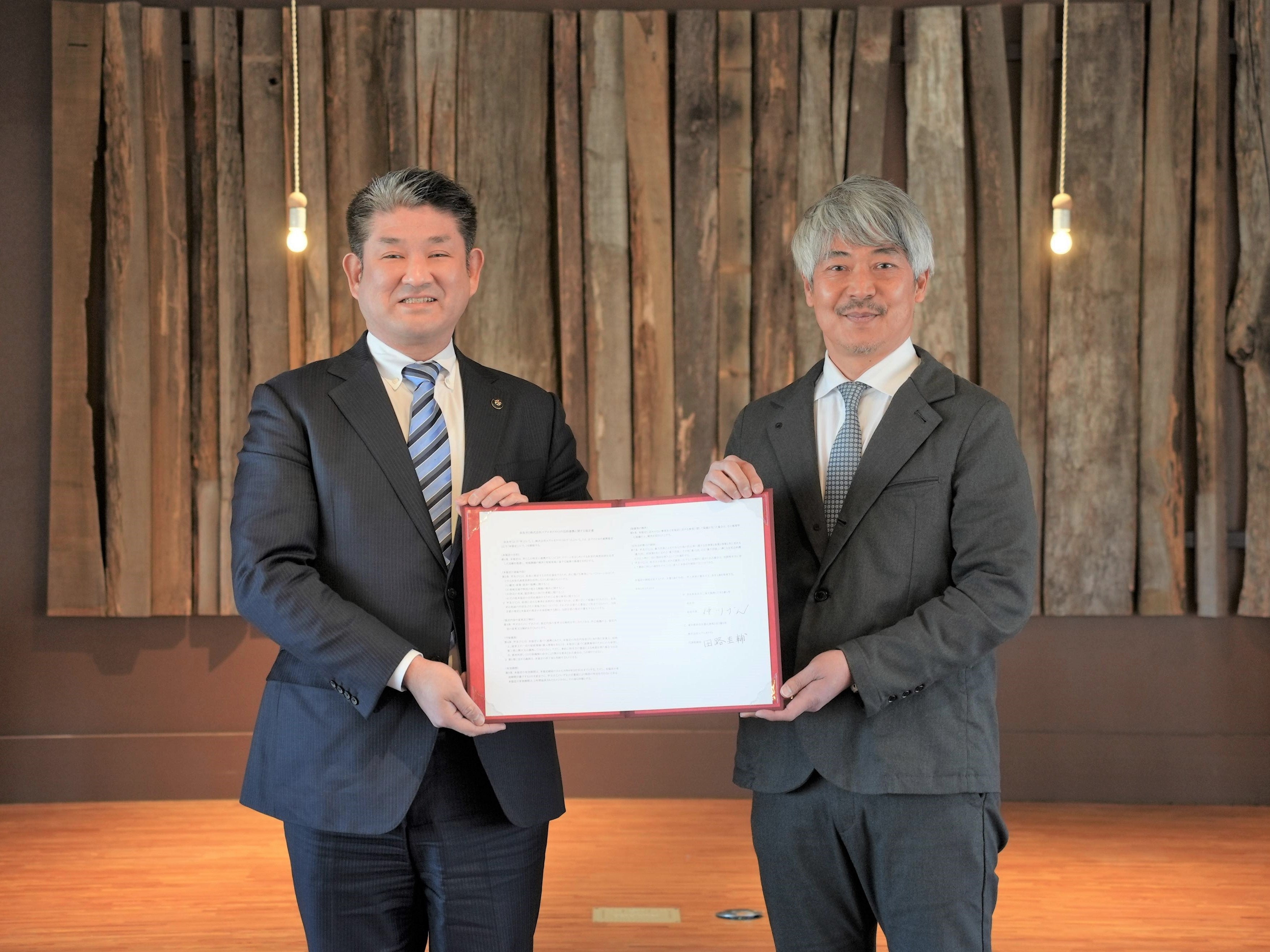 写真向かって左より、包括連携協定書を掲げる 奈良市長 仲川げん、エアロネクスト代表取締役CEO／NEXTDELIVERY代表取締役 田路圭輔 （月ヶ瀬ワーケーションルームONOONO）