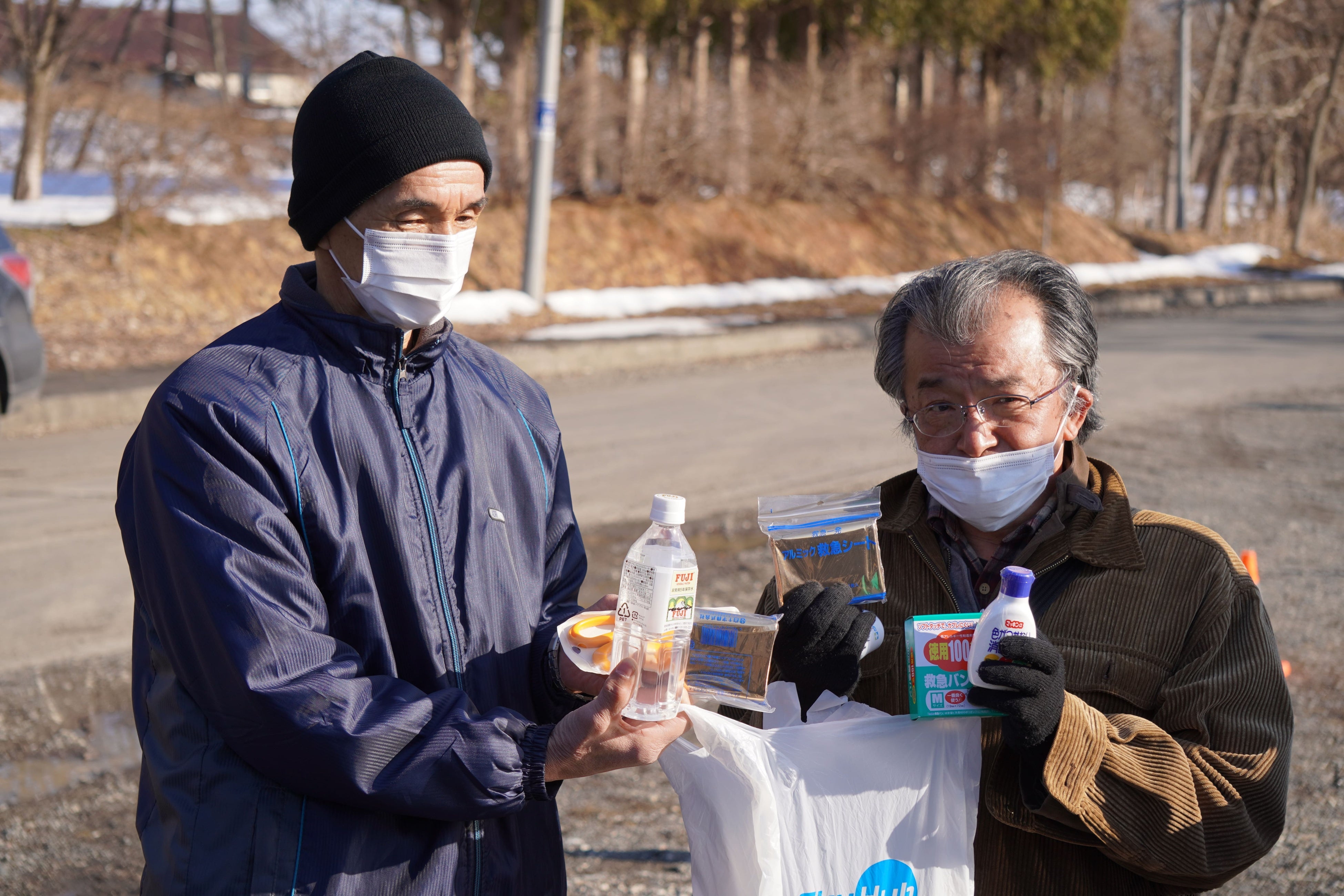 ドローンで運ばれた救援物資を 受け取る町民