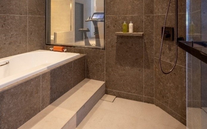 ライムストーン調のタイルを使用したバスルーム。