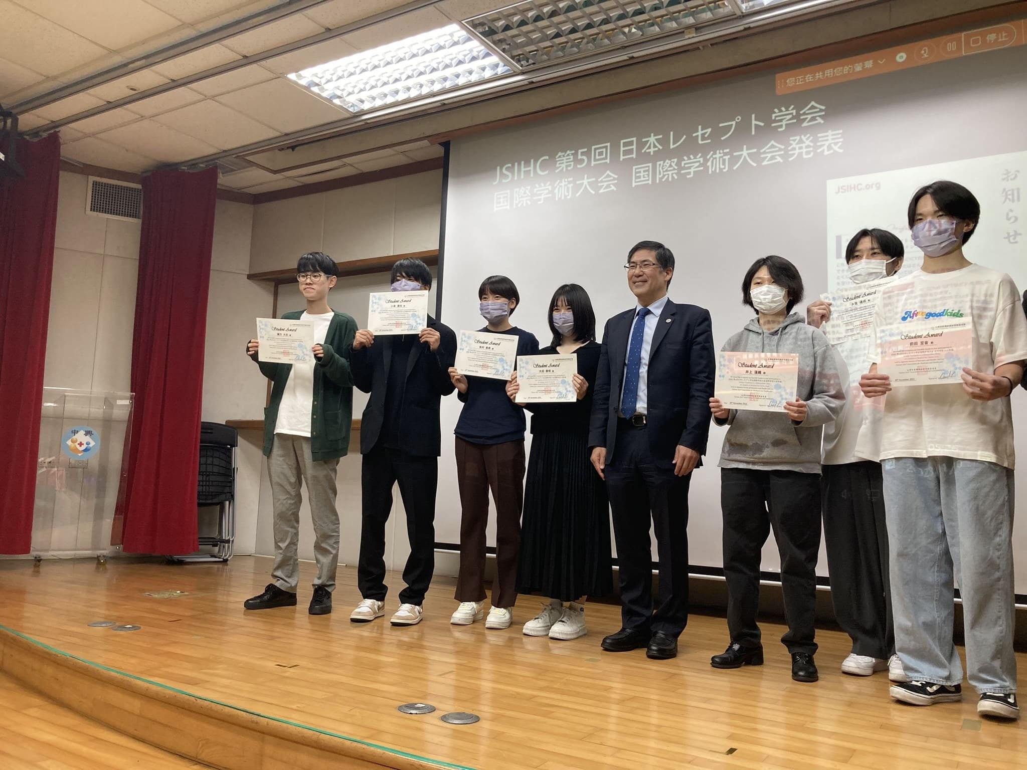 臺北市立聯合醫院で陳建志会長から表彰状を授与された発表学生たち  （右から3人目が井上さん、同4人目が陳会長、左端が緒方さん）