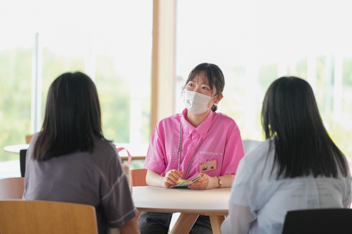 おしゃべりカフェで相談を受ける学生。ピンクの服が学生広報スタッフ。
