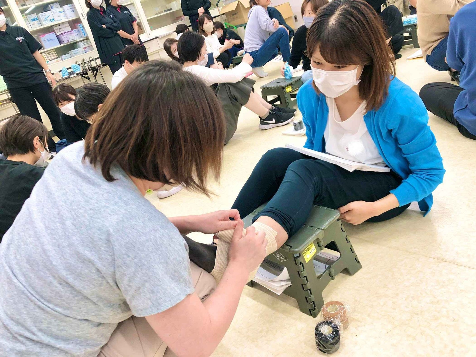 スポーツ外傷直後の応急処置やテーピングの巻き方について学んでいる様子
