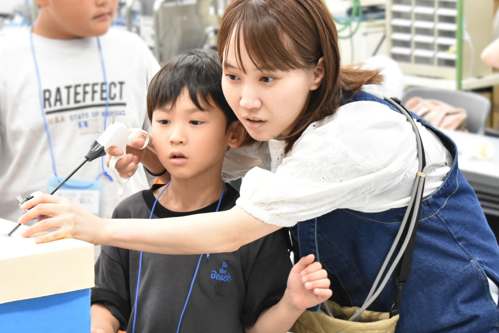 FSGカレッジリーグが開催した職業体験イベント「FSGおしごと講座2025 -サマースペシャル-」に参加している子どもと保護者