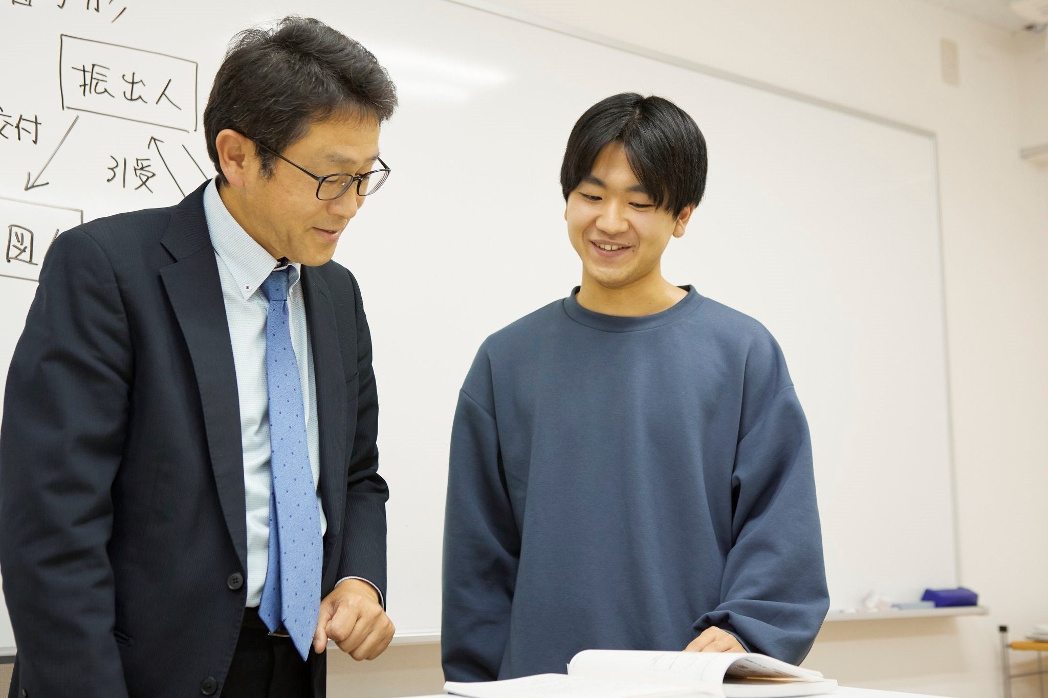 わからないところは　とことん質問する田代さん。担任の先生とのひとコマ。