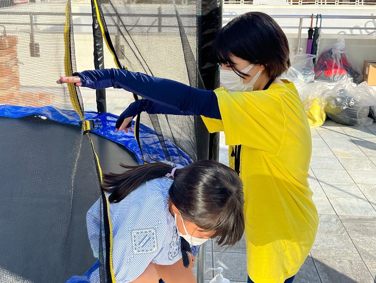 トランポリンの乗降を助ける学生