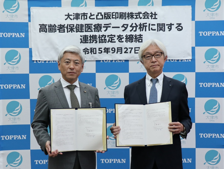 左から、大津市長 佐藤 健司、凸版印刷 西日本事業本部 常務執行役員 事業本部長 小谷 友一郎