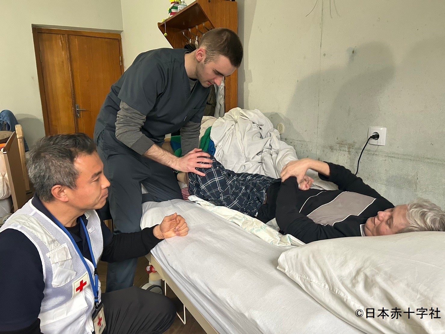 リハビリ中、患者の様子や現地理学療法士の施術を確認する中島（写真左）