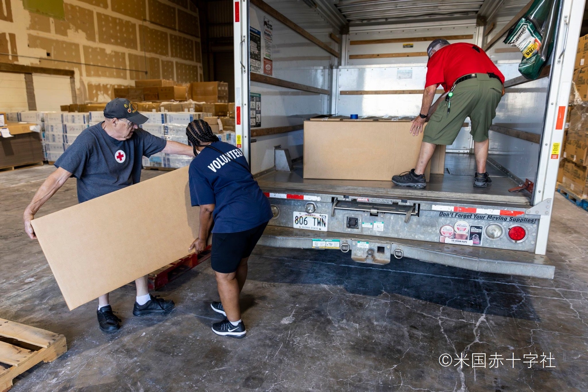 マウイの倉庫で被災者に配付する救援物資を準備する赤十字スタッフとボランティア
