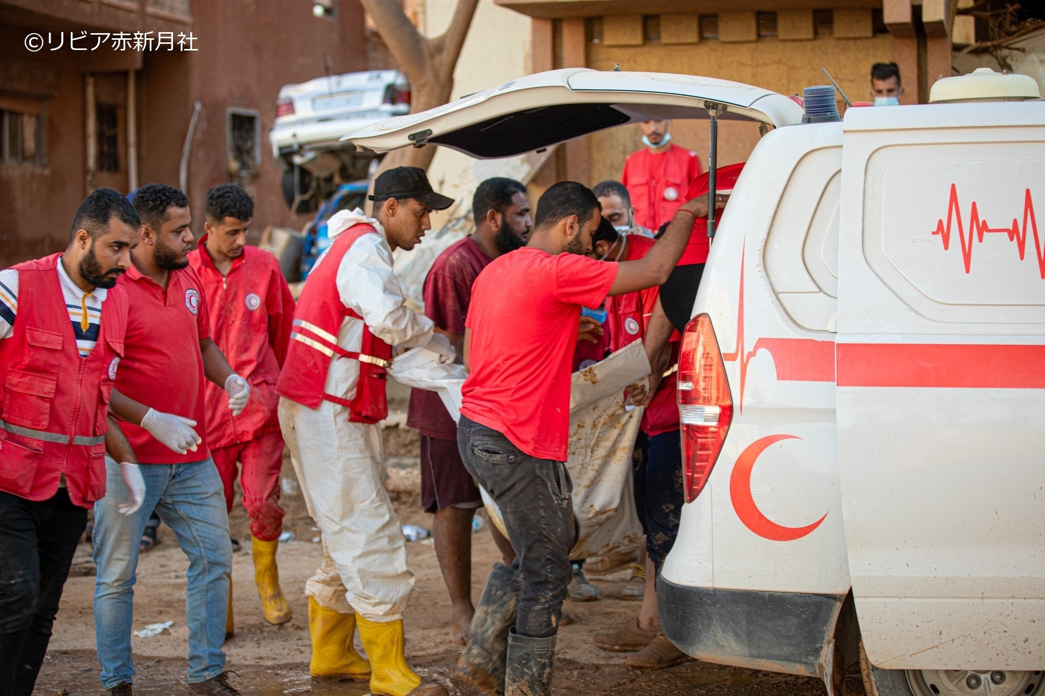 犠牲となった被災者を遺体袋に包み搬送・収容する赤新月ボランティア