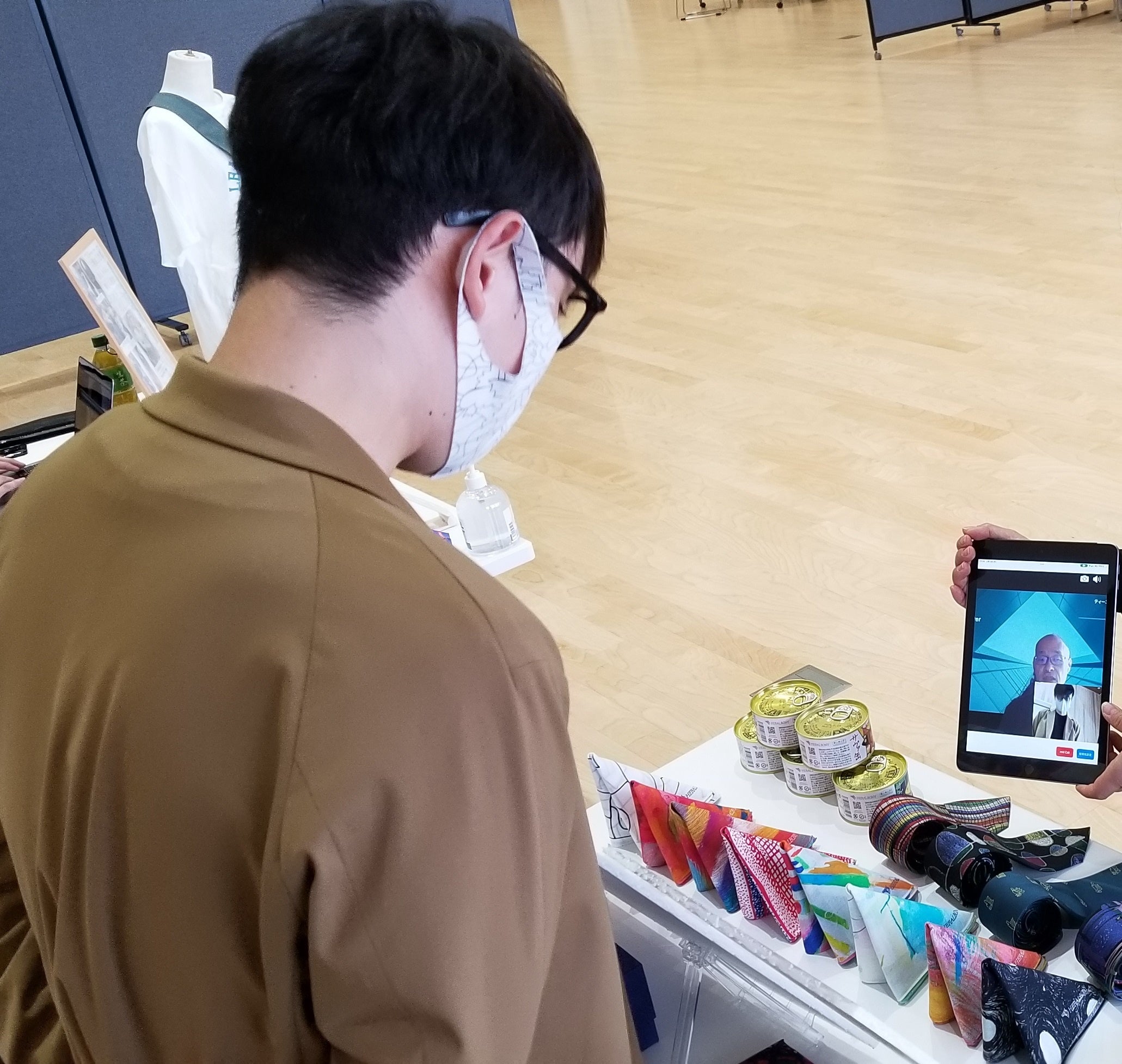 タブレット越しの来場者と話す出展者