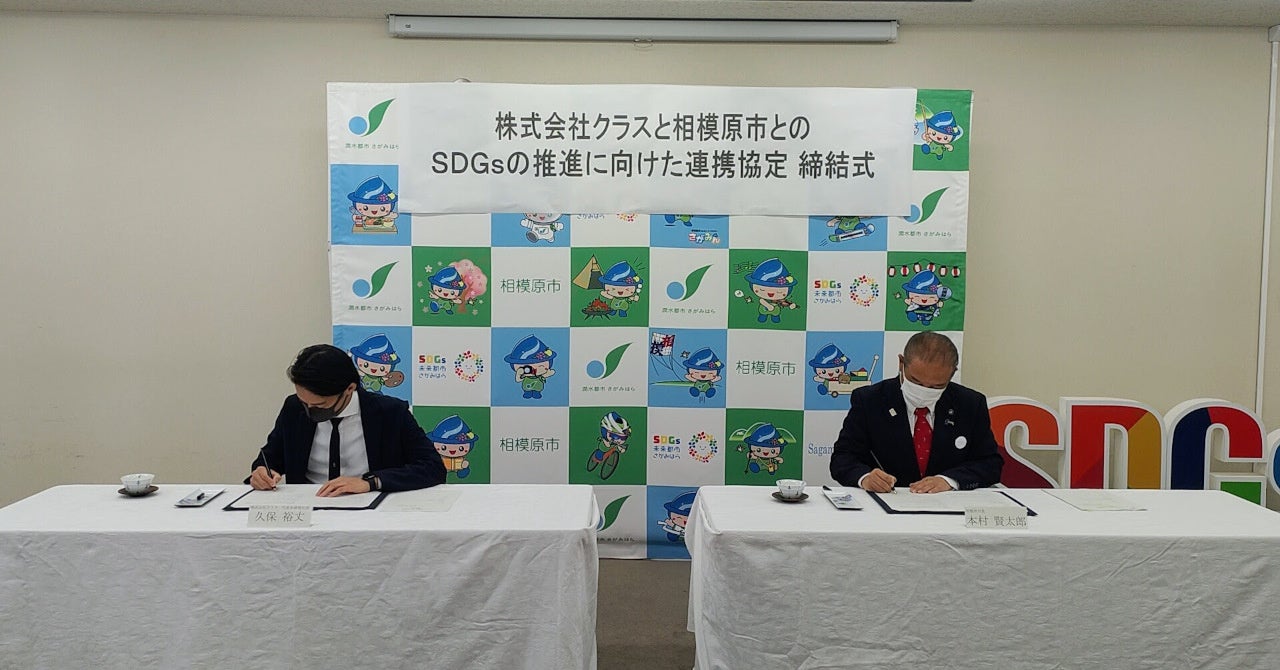 ​協定締結式にて協定書に署名する様子