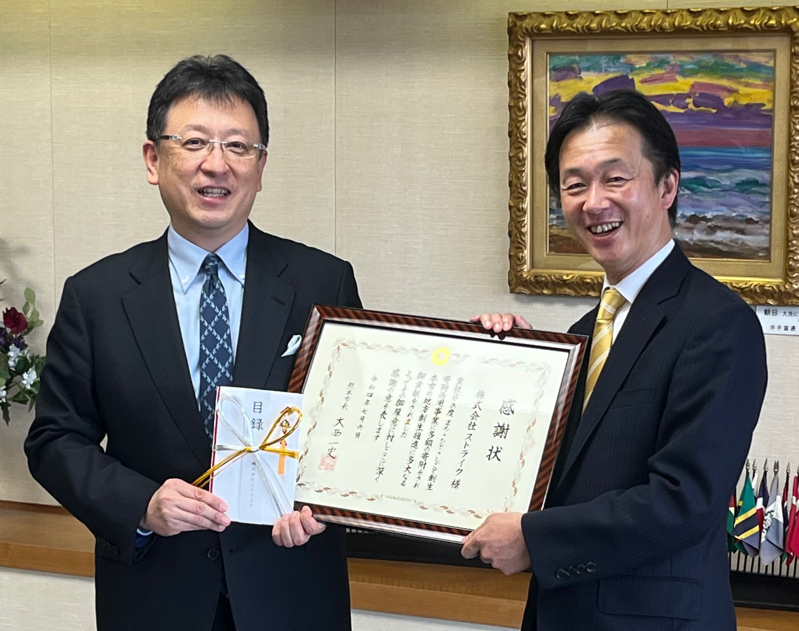 写真：大西一史・熊本市長（左）と荒井邦彦・ストライク社長（右）