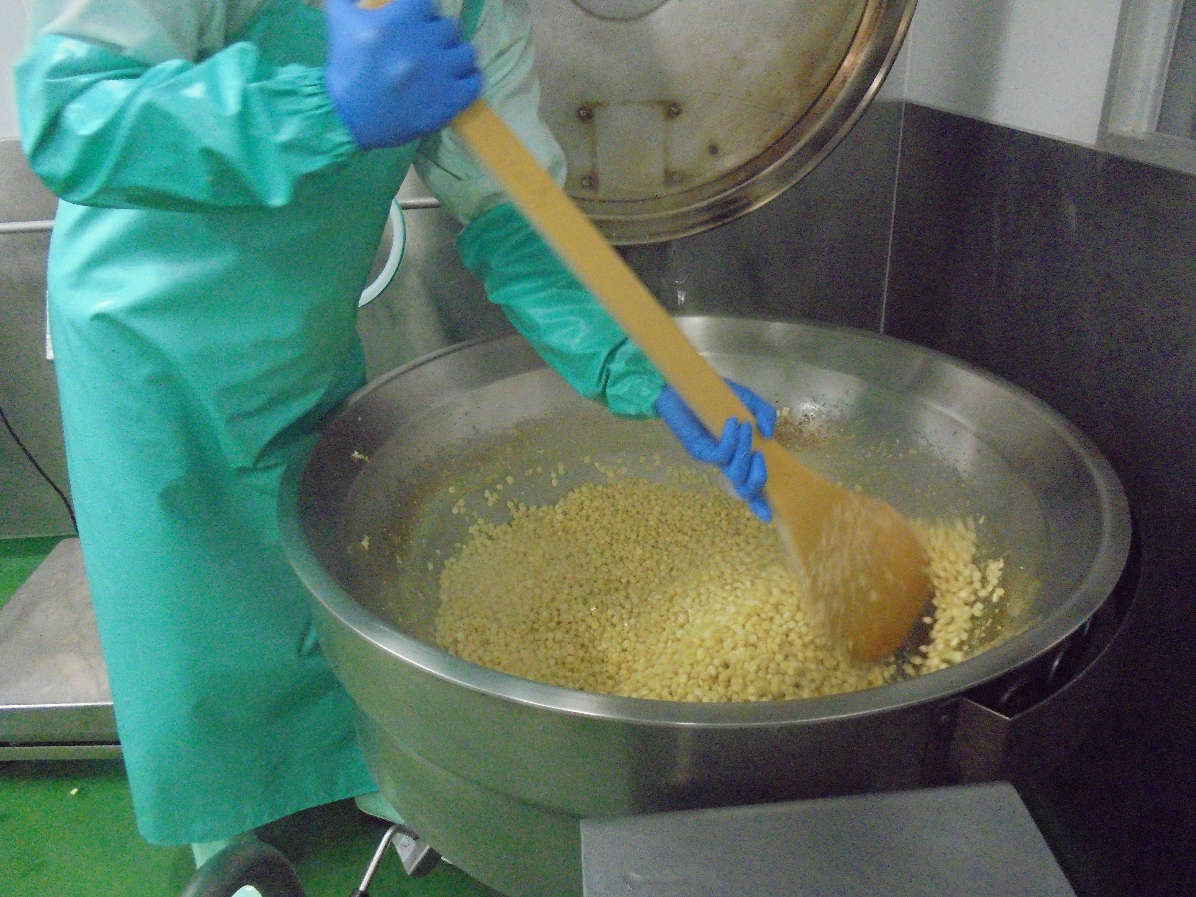 高温のガス窯で粒ひとつひとつに熱が入るよう終始手を止めずに炒める工程 このひと手間がおいしさにつながっている