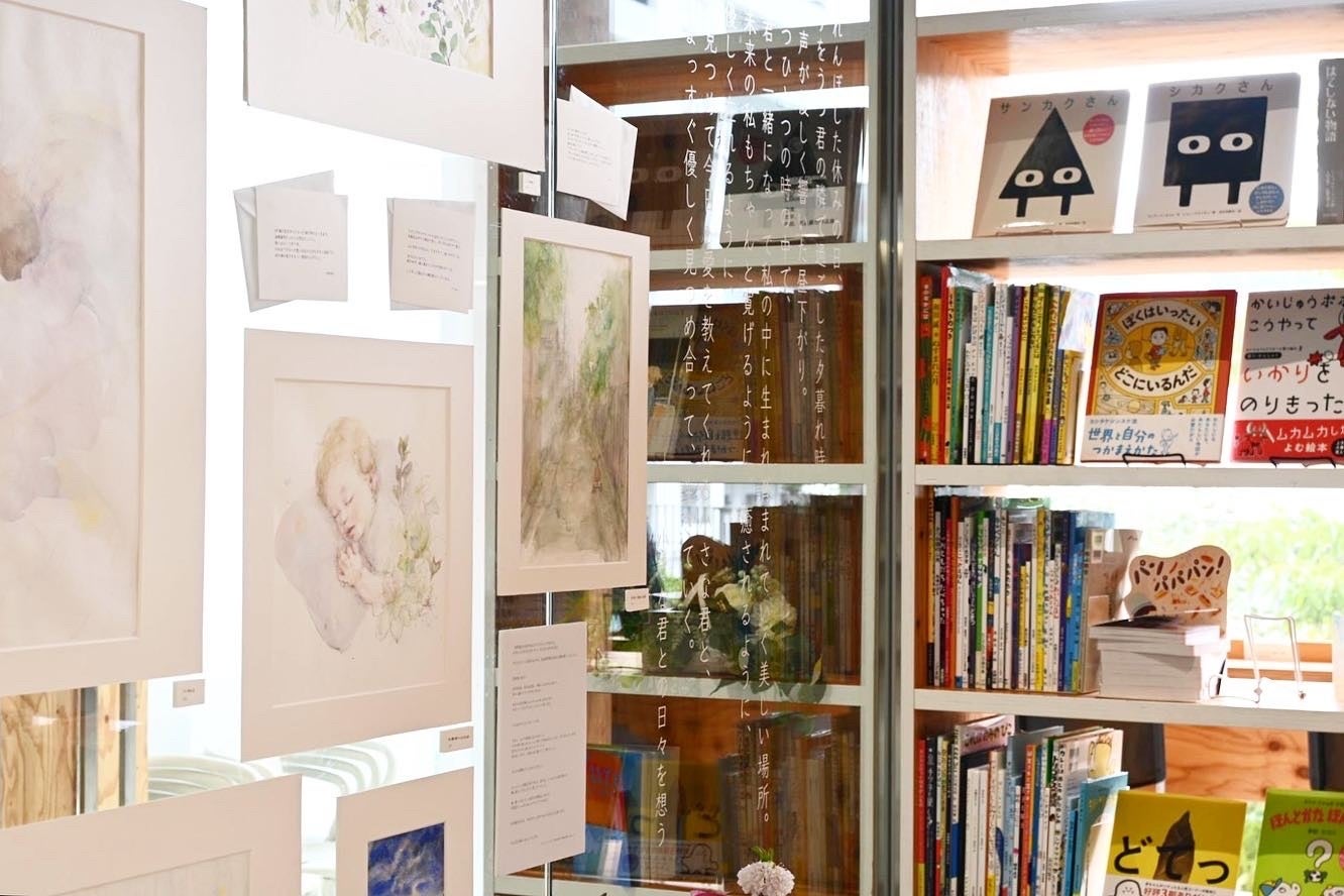 エッセイと共に、日常の様々なシーンを描いた原画やエピソードがガラスの壁を彩る