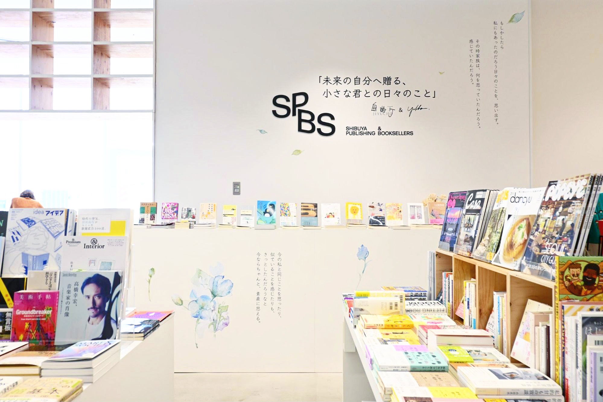 来場者を迎えるのは、色とりどりの本に囲まれた壁に描かれた言葉と花々
