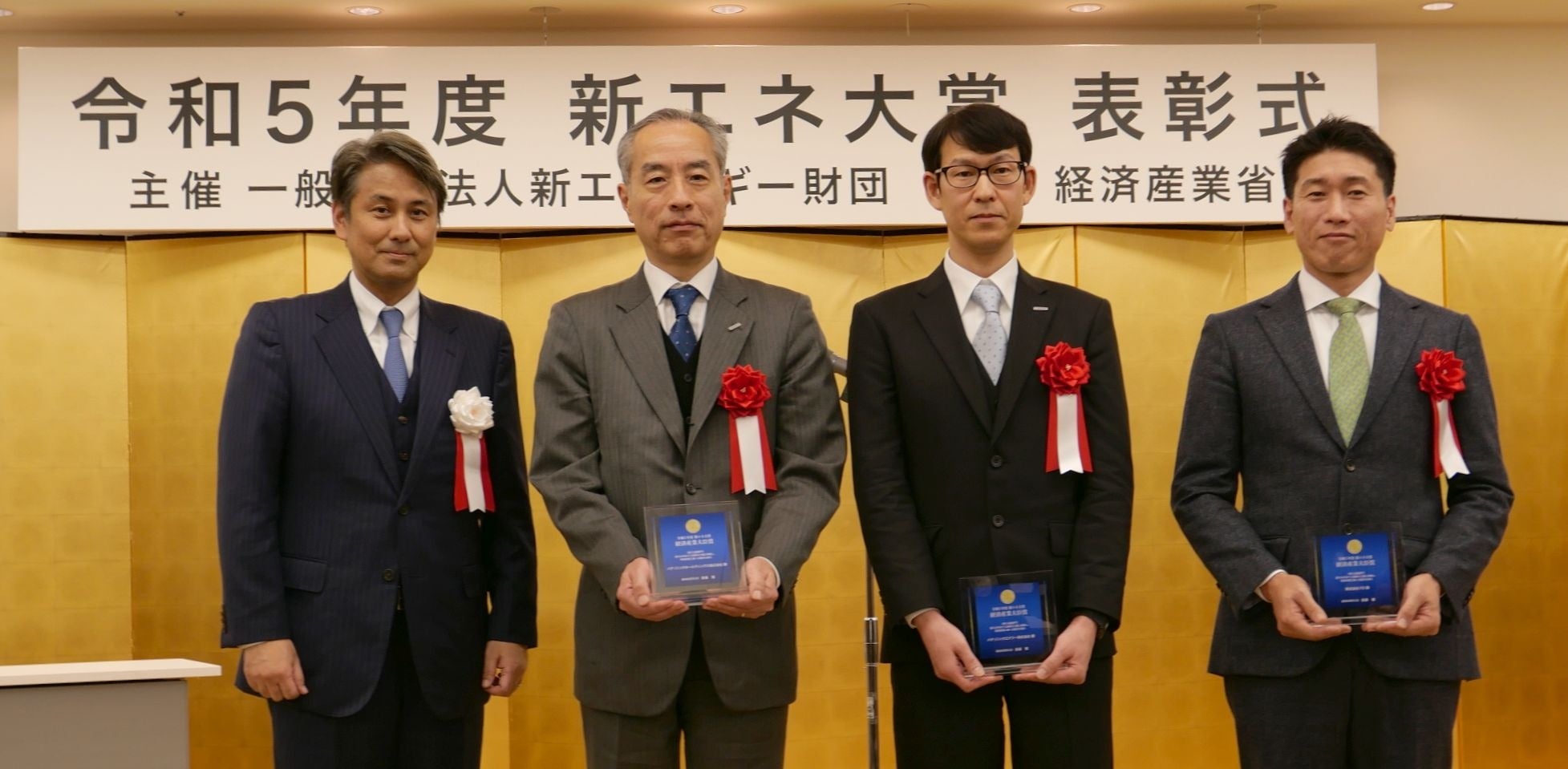表彰式での記念写真、 左から経済産業省 省エネルギー・新エネルギー部長 井上博雄氏、 パナソニック ホールディングス株式会社 グループCTO 小川立夫、 パナソニック エナジー株式会社 企画センター 課長 佐藤実、 株式会社FD 代表取締役 鈴木政司氏